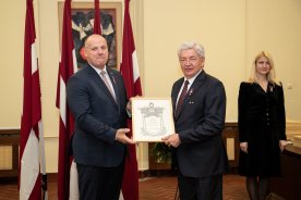 Aizsardzības ministrs pasniedz goda rakstu RTU rektoram Leonīdam Ribickim